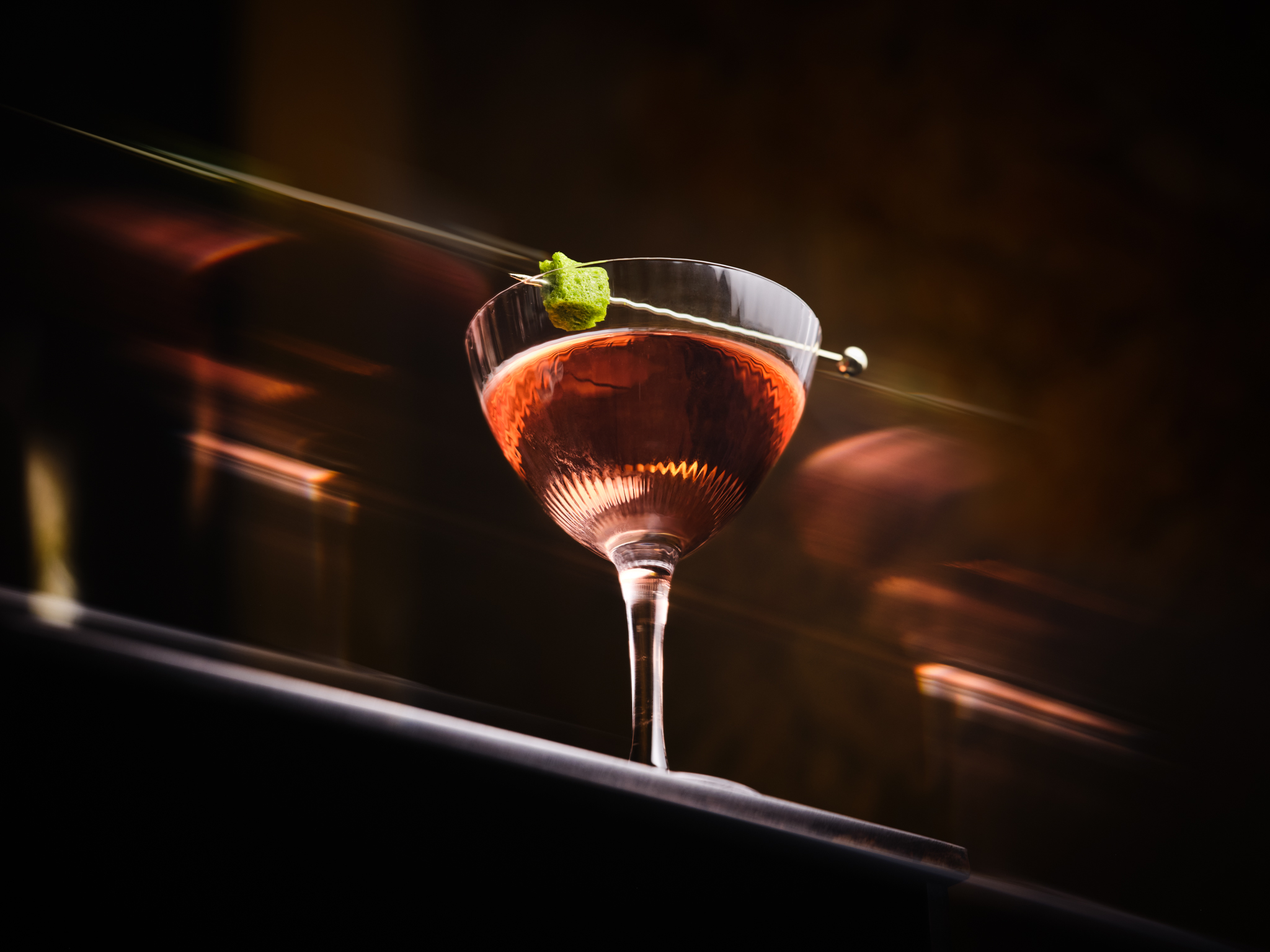 A copper-colored drink in a stemmed cocktail glass