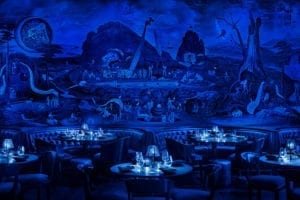 Low light dining area with large mural on the wall