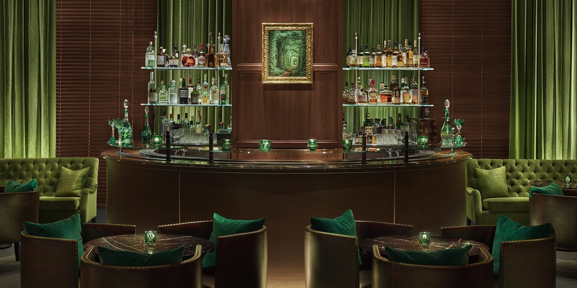 Bar del hotel con una zona de asientos amplia y detalles verdes
