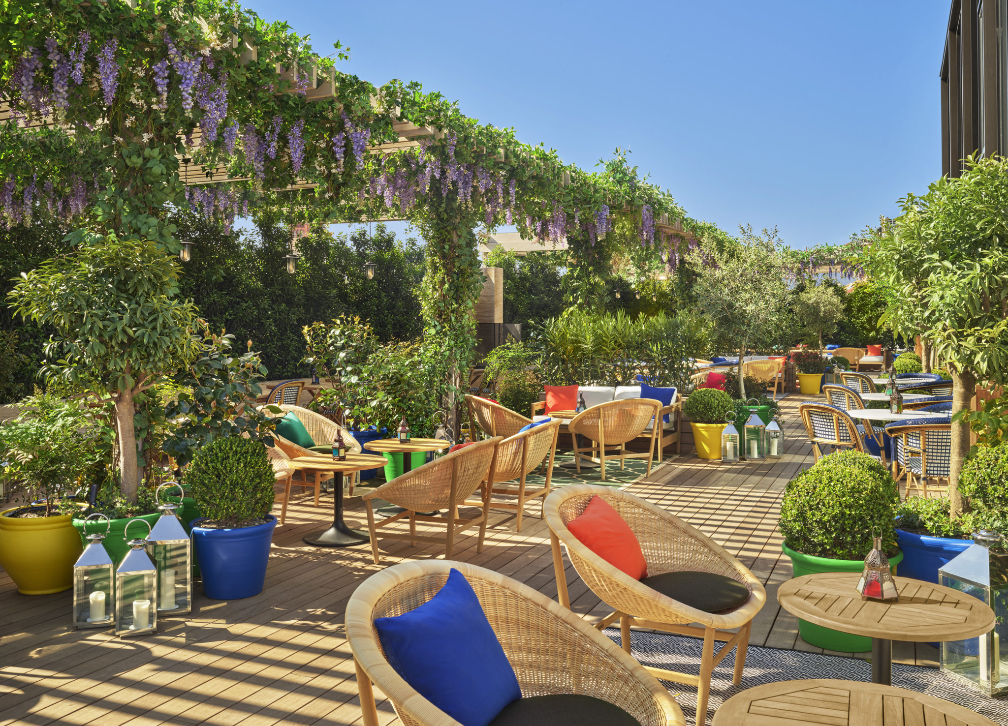 Dining area with hanging garden and colorful throw pillows and potted flora