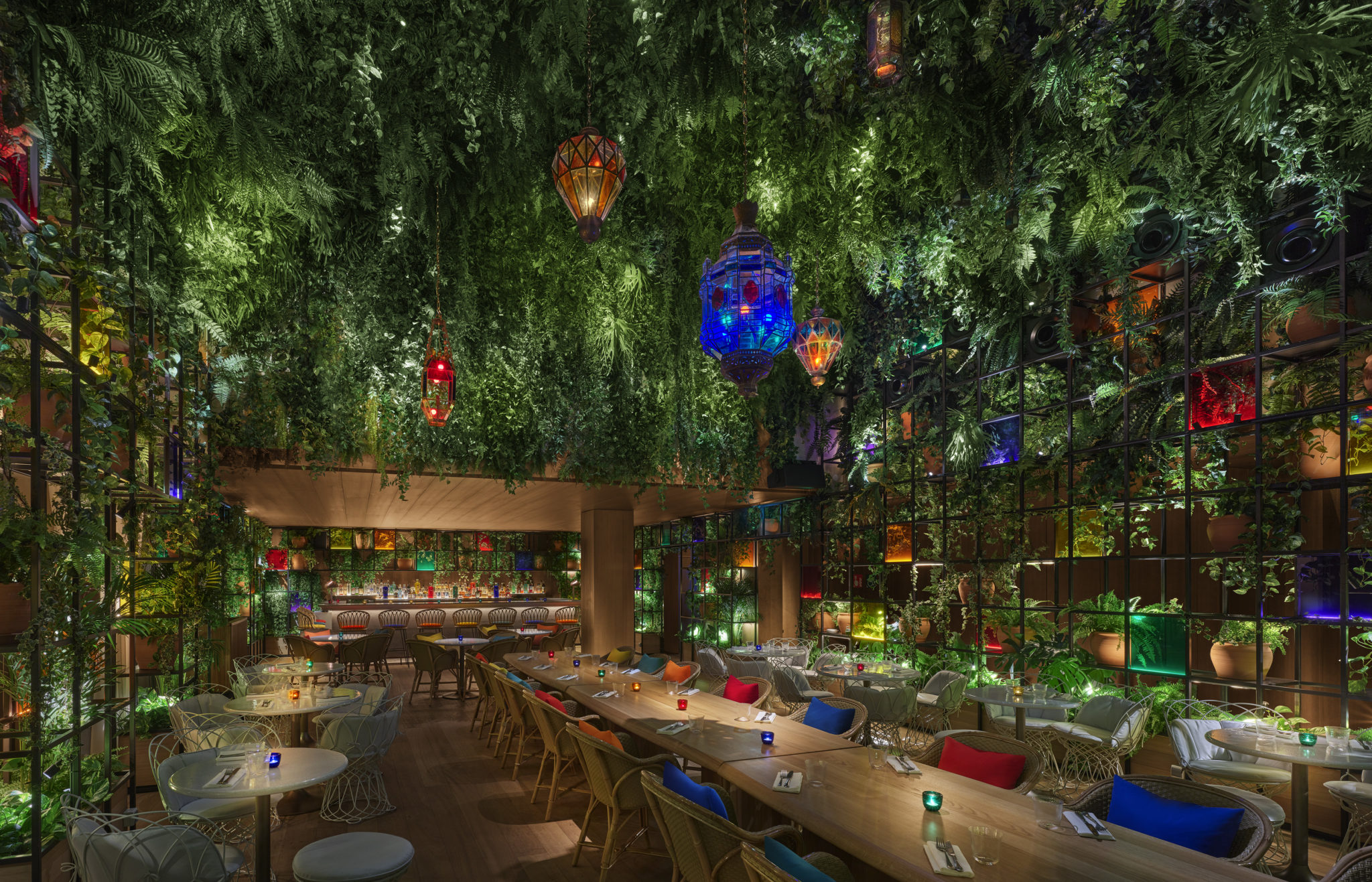 Dining area with hanging garden and colorful lanterns at night