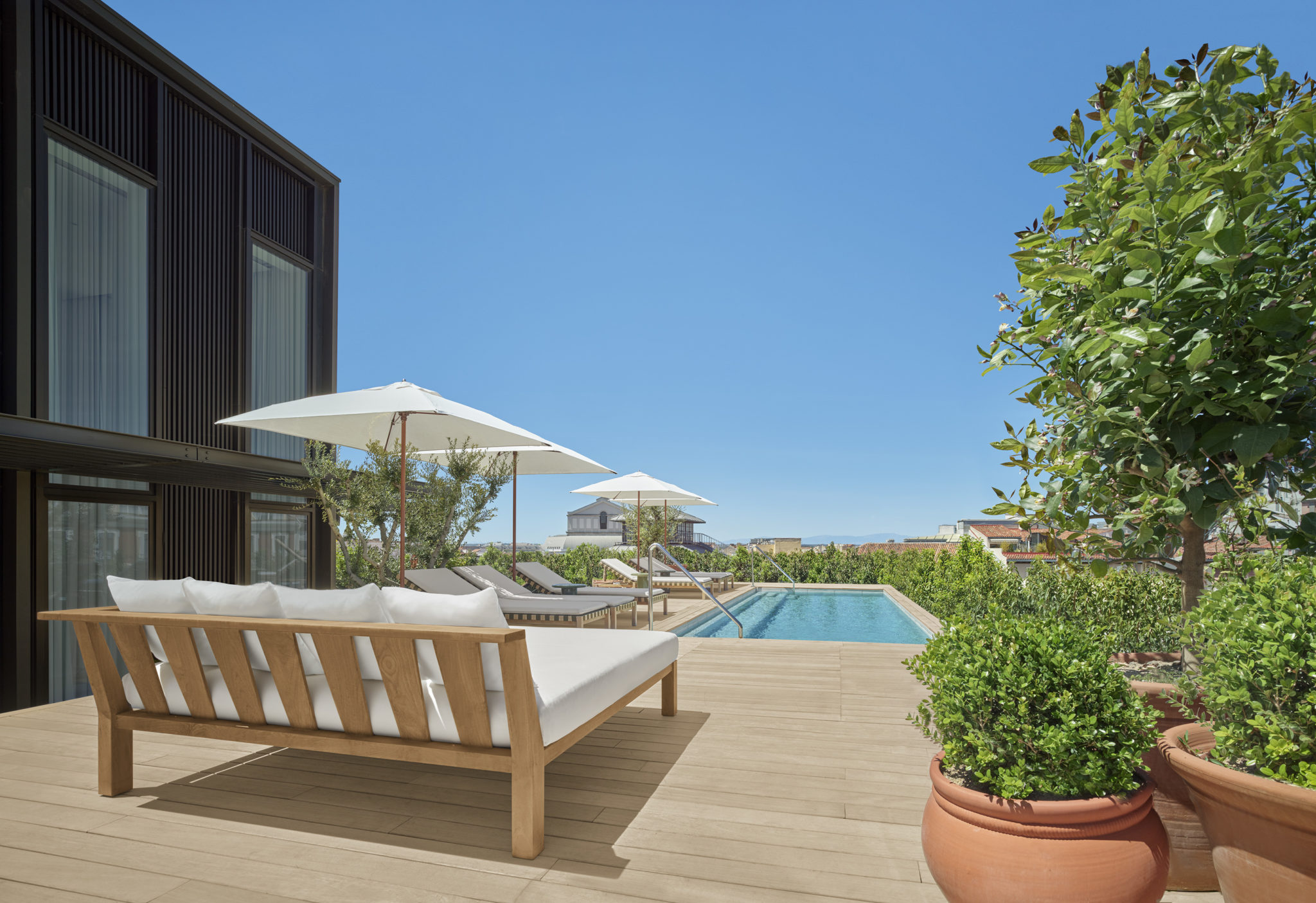 Private rooftop pool with sun loungers and umbrellas