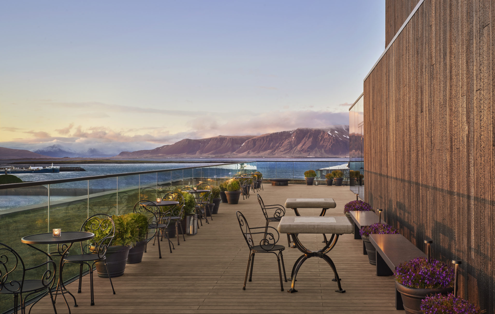 Outdoor dining terrace with water and mountain view
