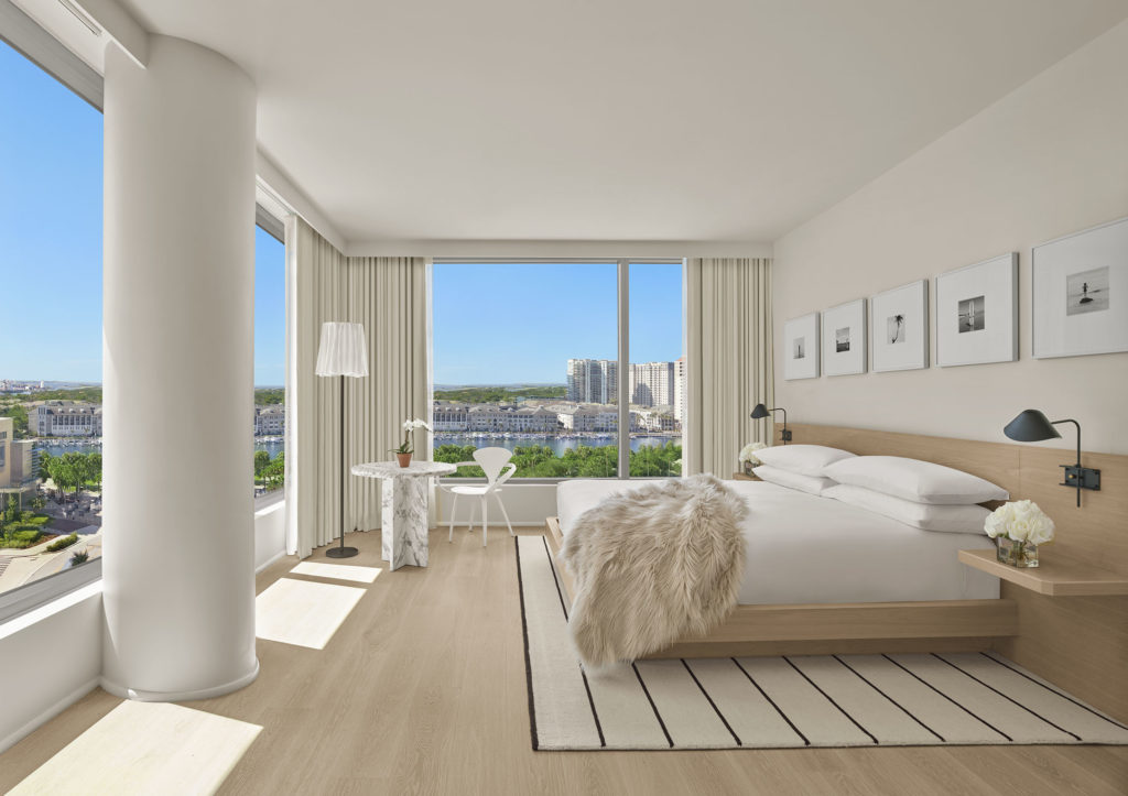 Corner guest room with expansive view and fur throw on bed