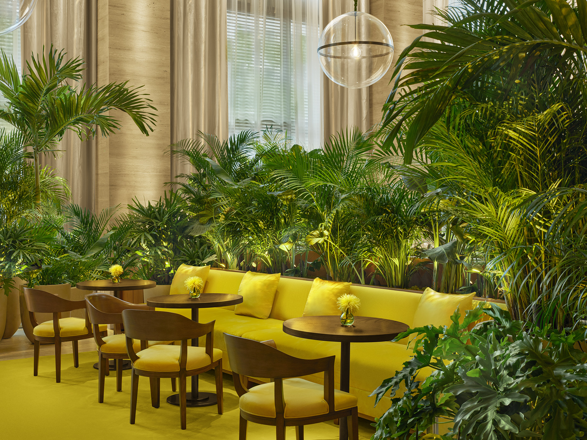 Bright yellow banquet seating surrounded by tropical palms