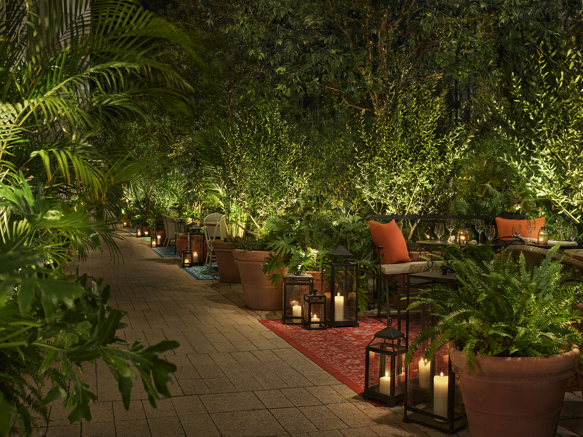 Semi-private outdoor seating with tropical flora and candles for ambiance