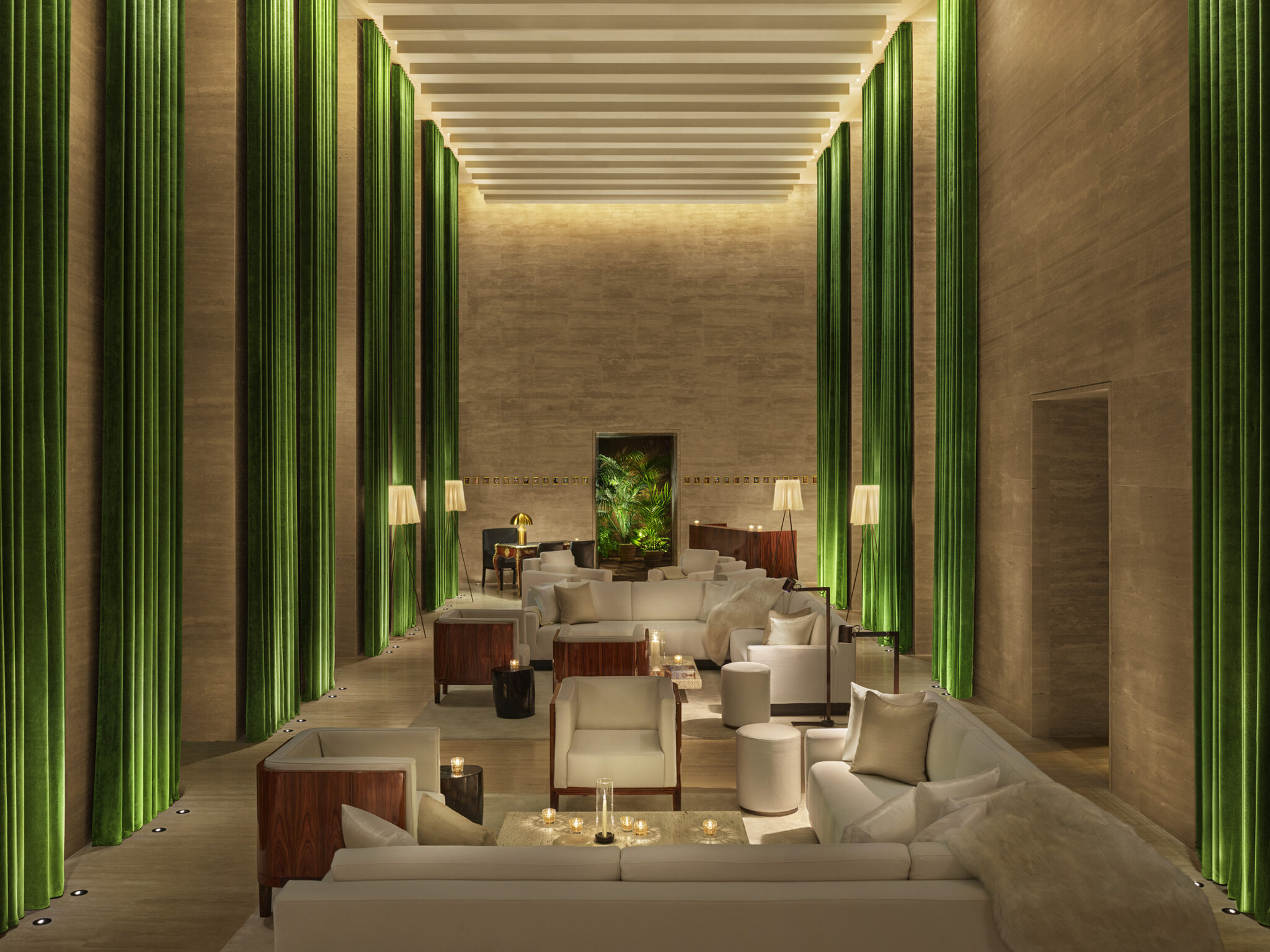 Asientos elegantes en el lobby con cortinas en tonos joya del piso al techo
