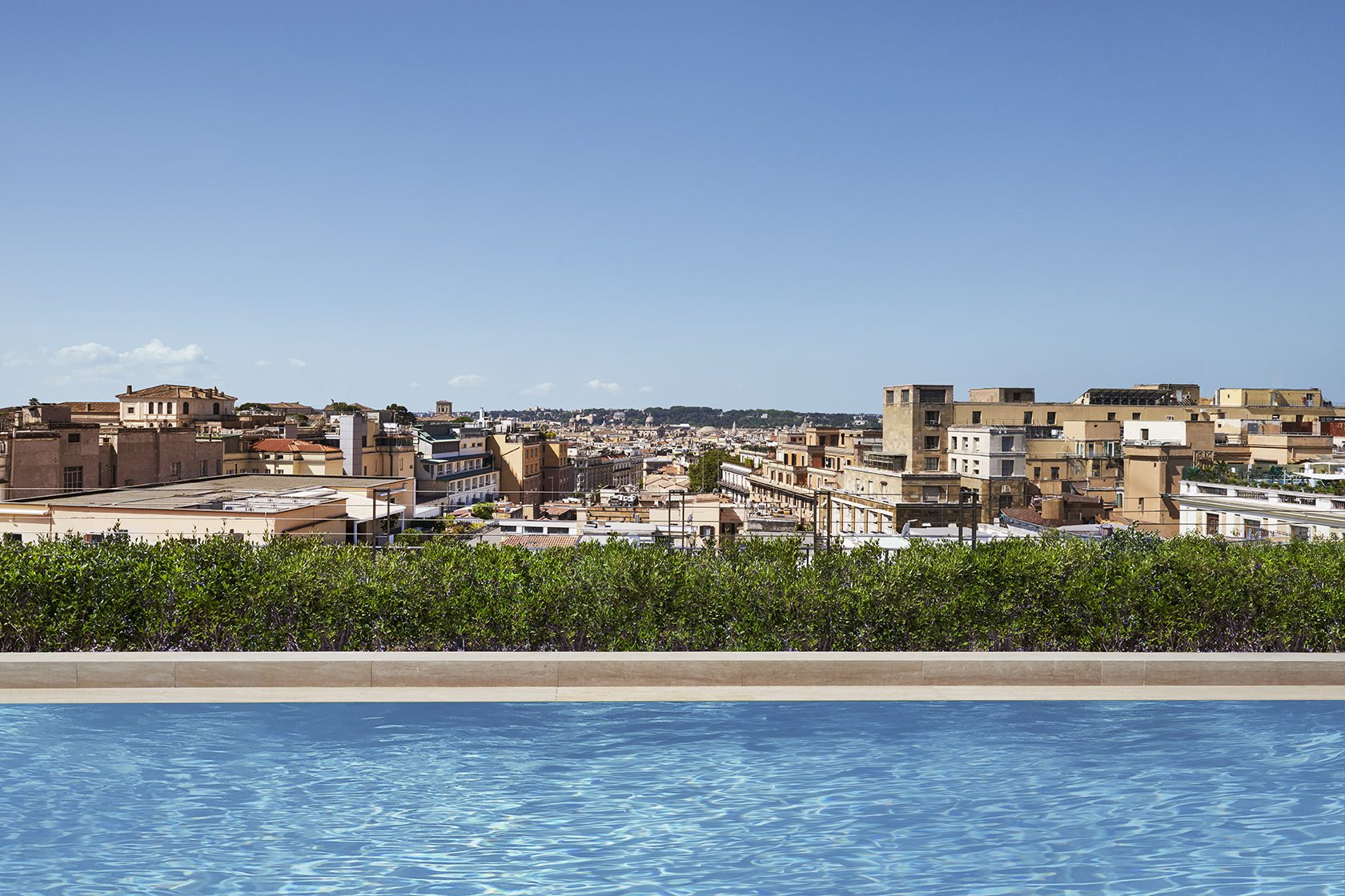 A view of the pool with a city skyline in the distance.
